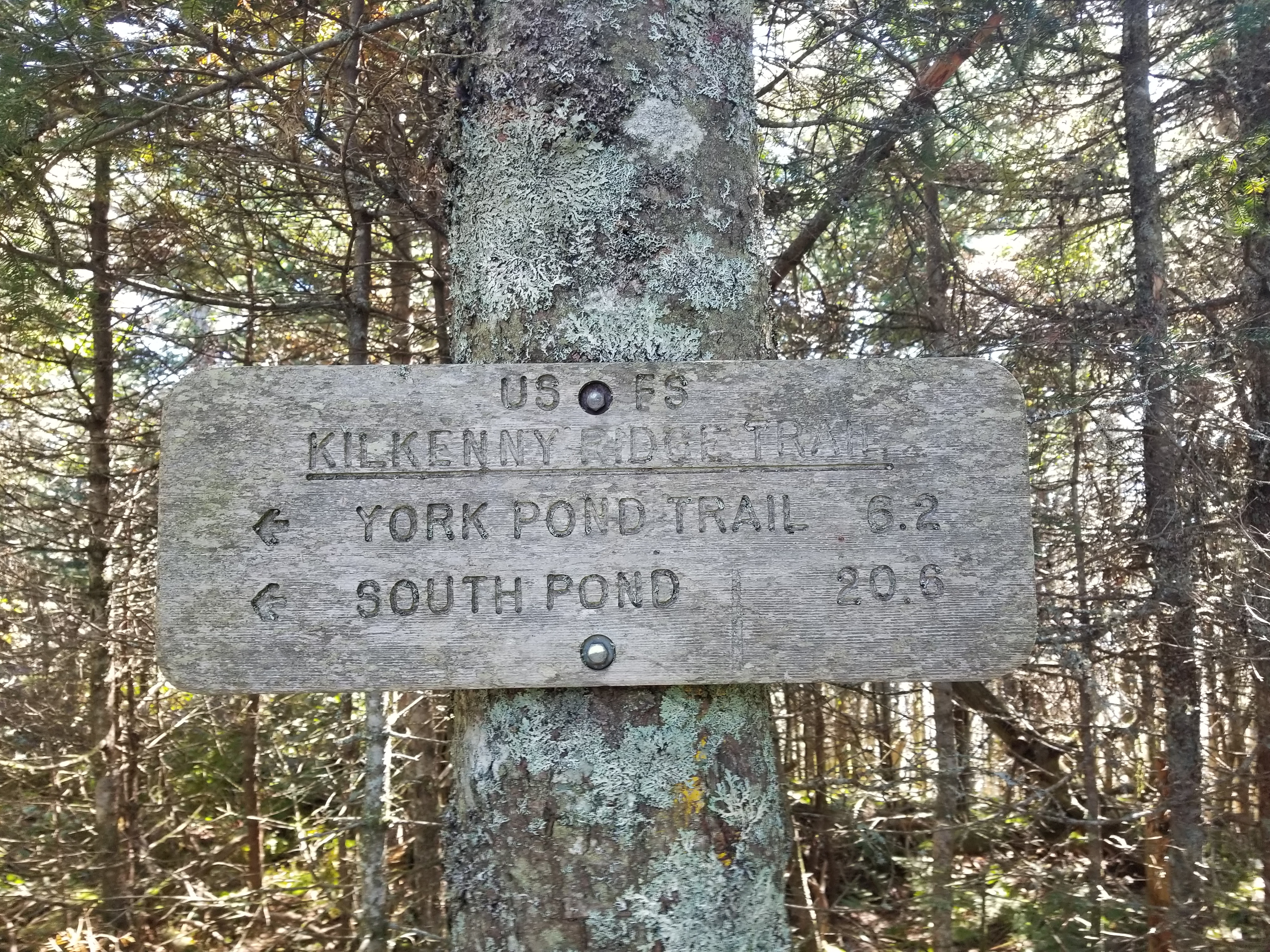 A sign at the summit providing distances to 2 more location